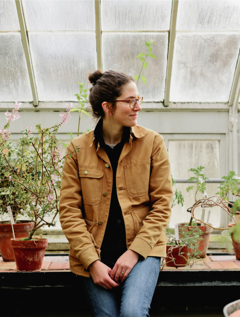 Jonge vrouw staat in kas