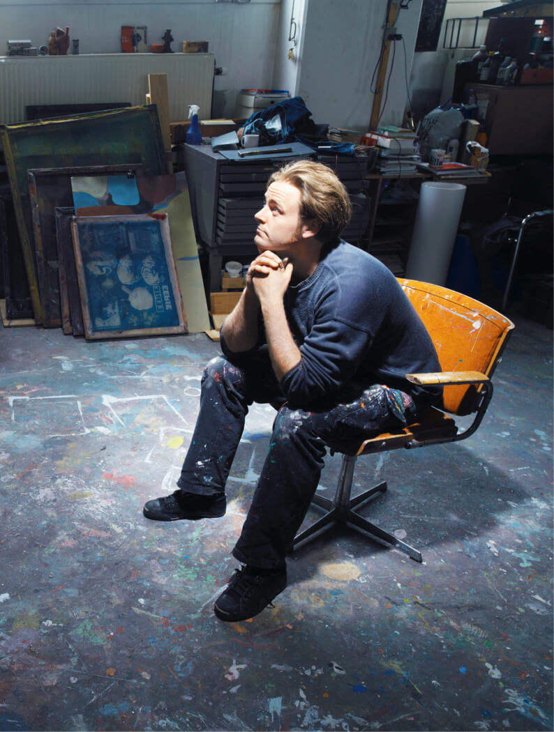 Mannelijke kunstenaar zit in zijn atelier